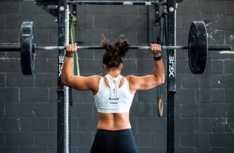 A person using fitness equipment designed to support lower back comfort during exercise, showcasing various gear like resistance bands, foam rollers, and ergonomic mats.