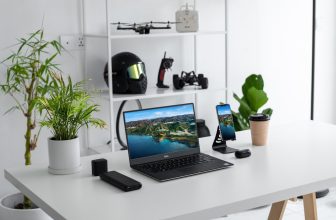 A modern desk setup featuring various gadgets that promote organization and efficiency, including cable organizers, a sleek monitor stand, and a minimalist desk lamp.