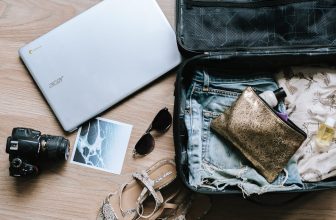 A collection of modern tech accessories including a laptop stand, portable charger, and noise-canceling headphones on a desk.